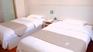 A hotel room with two beds, a bedside table with a phone and a green sign, and a glass door. - GreenTree Inn Shanghai Songjiang District Sijing Town Sijing Metro Station Express Hotel (Shanghai)