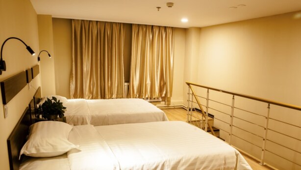 A modern hotel room with two beds, a staircase, and a view of the city. - GreenTree Inn DaLian Ganjingzi District Airport New District Lazishan Express Hotel (Dalian)