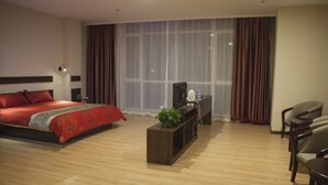 A hotel room with a bed, a TV, a desk, and a chair. - GreenTree Inn DaLian Ganjingzi District Airport New District Lazishan Express Hotel (Dalian)
