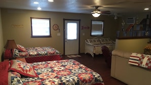 A bedroom with two beds, a ceiling fan, a window, and a door. - Scriv's Haus (Winters)