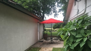 A patio with a stone pathway, a table with chairs, and a red umbrella. - Scriv's Haus (Winters)
