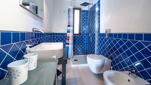 A bathroom with a large bathtub, a separate shower area, and a toilet.