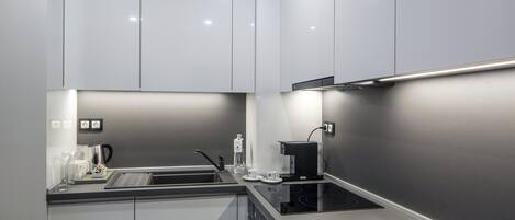 Una cocina moderna con estufa integrada, lavaplatos y cafetera.