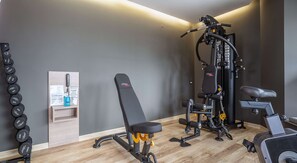 A gym with a bench, weight machine, and a rack of dumbbells. - Best Western Premier Plovdiv Hills (Plovdiv)