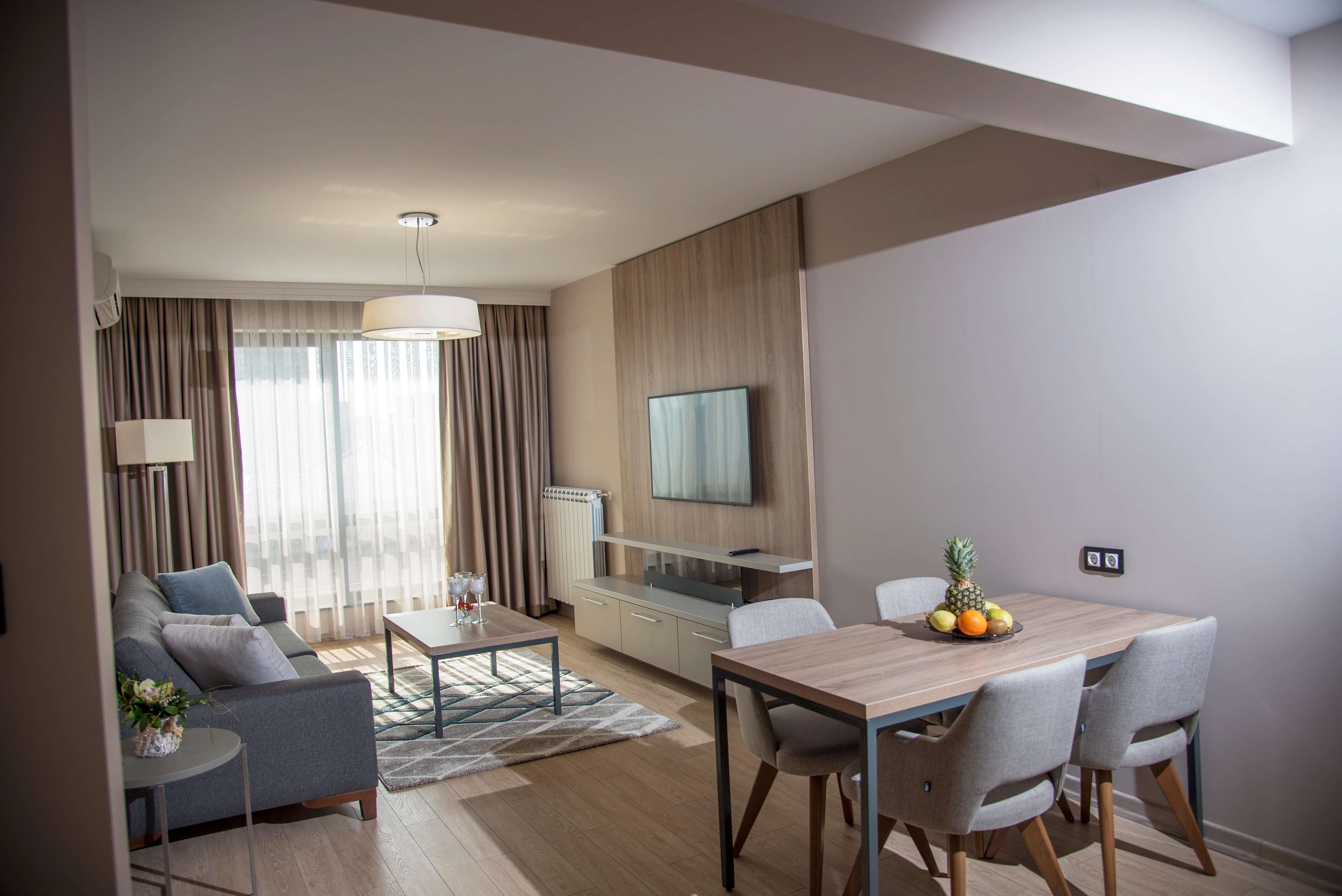 A modern living room with a sofa, coffee table, and dining table set.