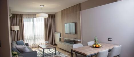 A modern living room with a sofa, coffee table, and dining table set.