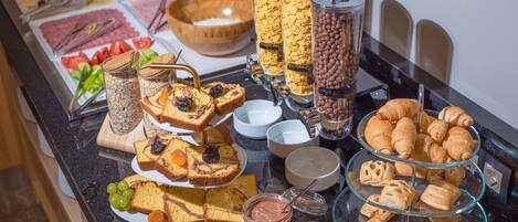 A buffet with various food items including bread, pastries, and condiments.