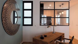 A modern kitchen with wooden cabinets, a large window, and a pendant light.
