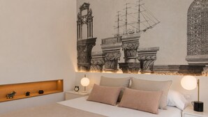 A bed with a headboard, bedside tables, and a wall-mounted artwork.