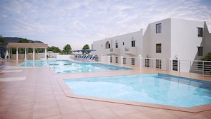 Una piscina al aire libre de temporada, sombrillas