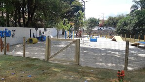 A fenced outdoor play area with a wall featuring graffiti and a sign that reads "PARCÃO". - House in a gated community in São Francisco da Praia, São Sebastião/SP (Praia de São Francisco, São Sebastião)