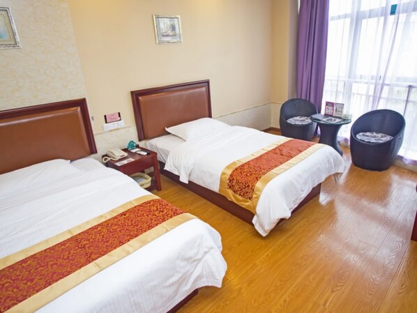 A hotel room with two beds, a small table, a chair, and a window with curtains. - GreenTree Inn Shanghai Sheshan national tourist resort Express Hotel (Shanghai)