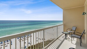 A balcony with a view of the beach and ocean.