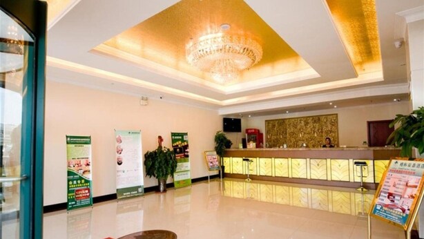 A hotel reception area with a modern design, featuring a chandelier, a reception desk, and informational posters on the walls. - GreenTree Inn TianJin Jinnan District Xiaozhan Training Park Express Hotel (Tianjin)