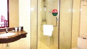 A bathroom with a glass-enclosed shower, a sink with a marble countertop, and a mirror.