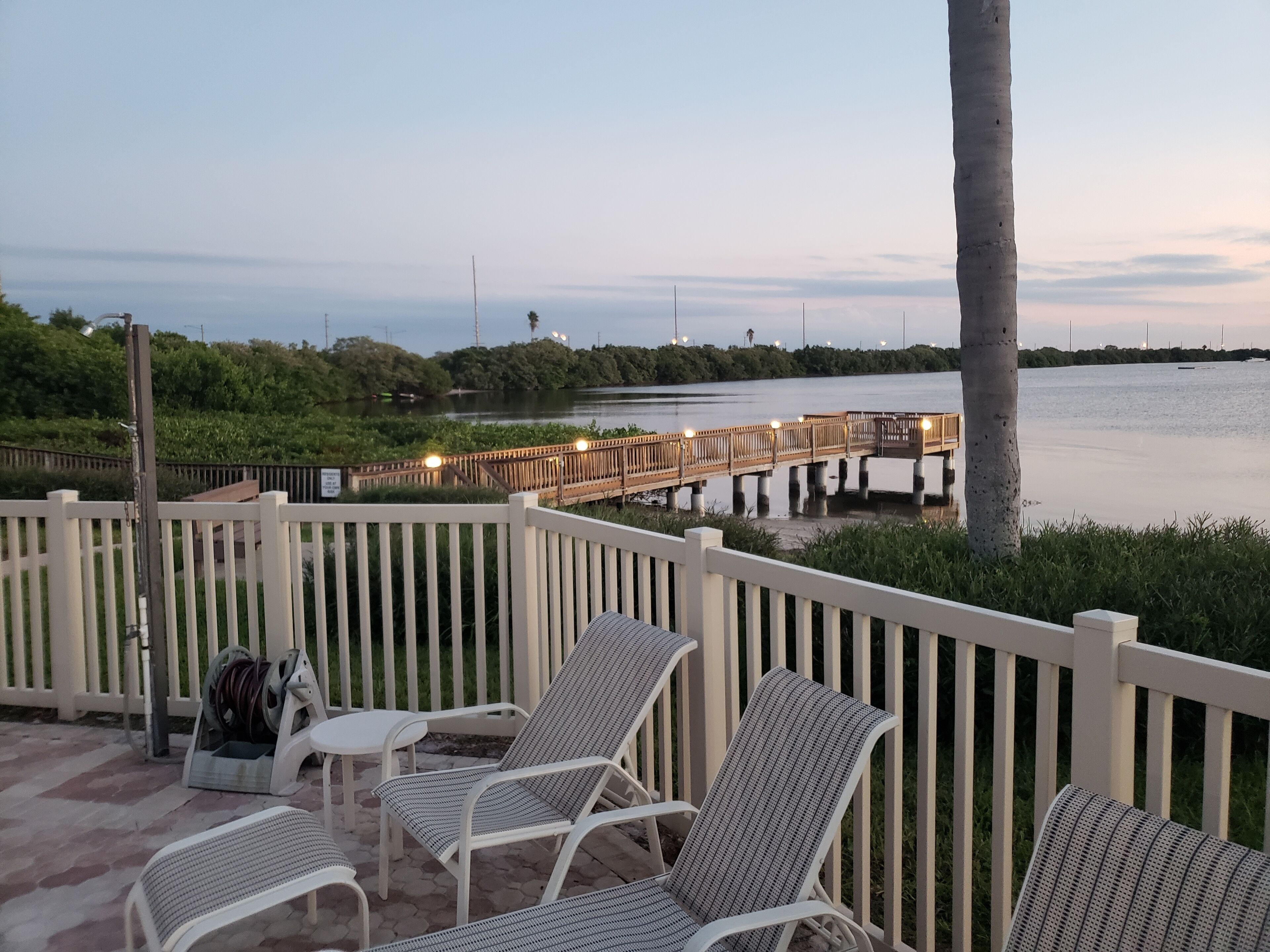 Eine Terrasse mit Sitzgelegenheiten und Blick auf ein Gewässer.