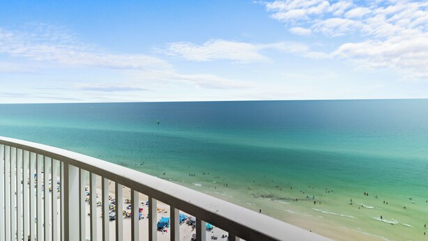 A beach view from a balcony with clear skies and calm waters. - Emerald Isle 1708 Just Remodeled! Stunning! Front Row Beach Chairs Included! (Panama City Beach)