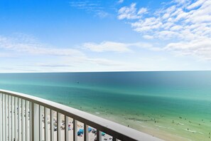 A beach view from a balcony with clear skies and calm waters. - Emerald Isle 1708 Just Remodeled! Stunning! Front Row Beach Chairs Included! (Panama City Beach)