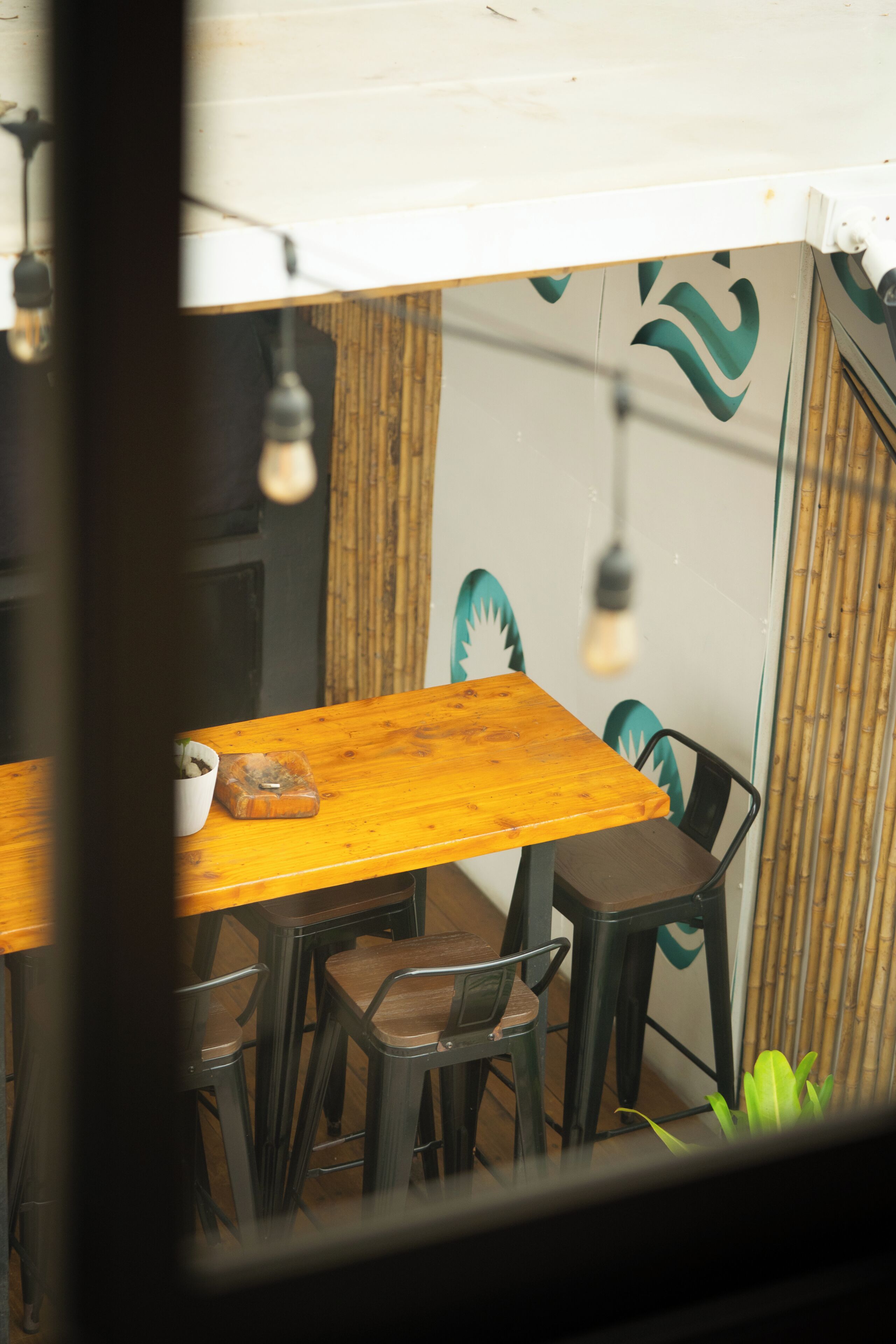 A wooden table with chairs, a bowl, and a light bulb hanging from the ceiling.