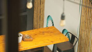 A wooden table with chairs, a bowl, and a light bulb hanging from the ceiling.