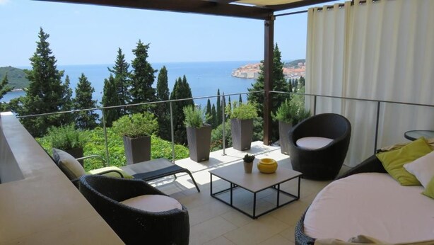 A balcony with a view of the sea, furnished with chairs and a table. - Villa King (Dubrovnik)