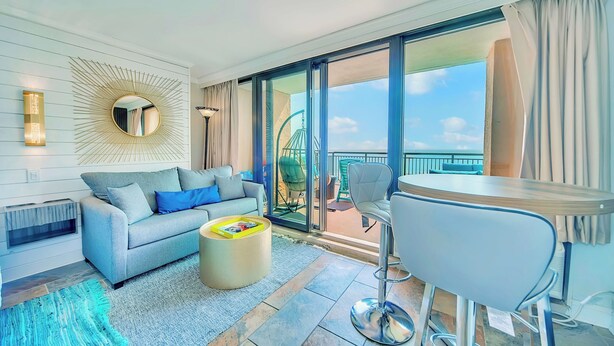 Ein modernes Wohnzimmer mit einer Couch, einem Couchtisch und einem Balkon mit Blick.
