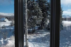 Un paysage enneigé avec une maison et des arbres.