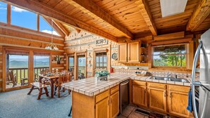 Un'ampia cucina con mobili in legno, una grande isola e vista sulle montagne.