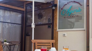 A breakfast setup with a table, chairs, and a menu board. - B&B Agorà Bisceglie (Bisceglie)