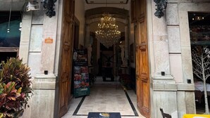 La entrada del Hotel Luna, con un arco imponente, una araña y un cartel sobre la puerta.