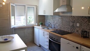 Una cocina moderna con armarios blancos, un lavamanos de acero inoxidable y un salpicadero con estampado.