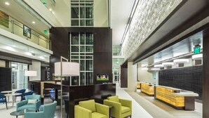 A modern hotel lobby with a central seating area, a reception desk, and a high ceiling with decorative lighting. - ***PRICE DROPS, SPECIAL OFFER AUG 24/30*** Summer Get Away before School (Myrtle Beach)