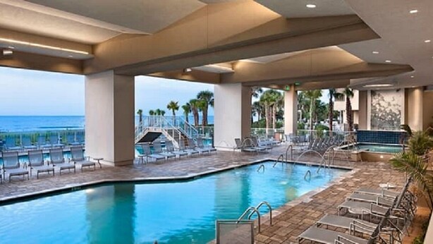 A pool area with lounge chairs and a view of the ocean. - ***PRICE DROPS, SPECIAL OFFER AUG 24/30*** Summer Get Away before School (Myrtle Beach)