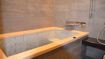 A modern bathroom with a freestanding bathtub, a shower area, and a built-in bench.