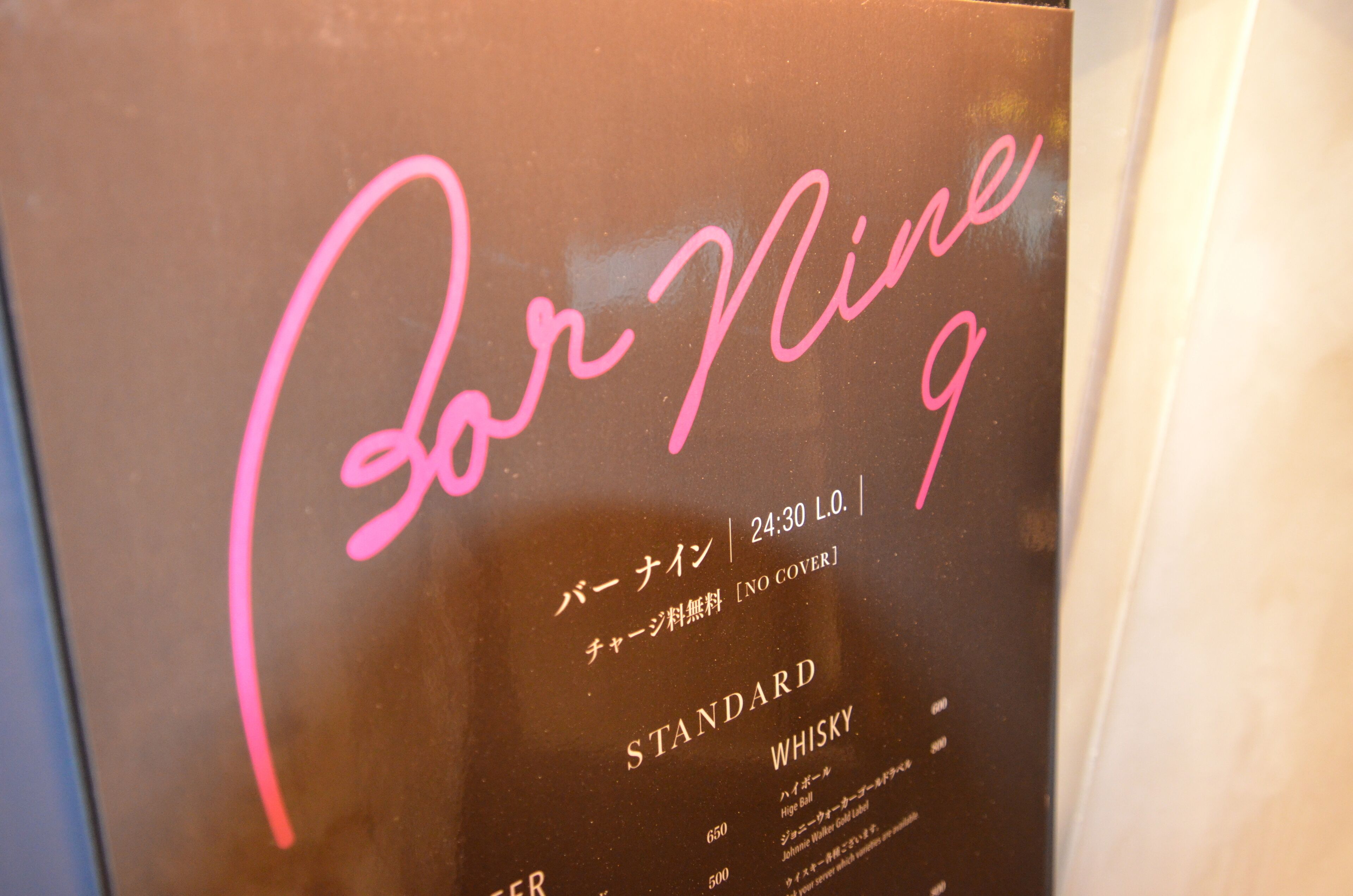Un letrero con el texto 'For Mine 9' y 'STANDARD WHISKY', junto con texto en japonés y un precio.