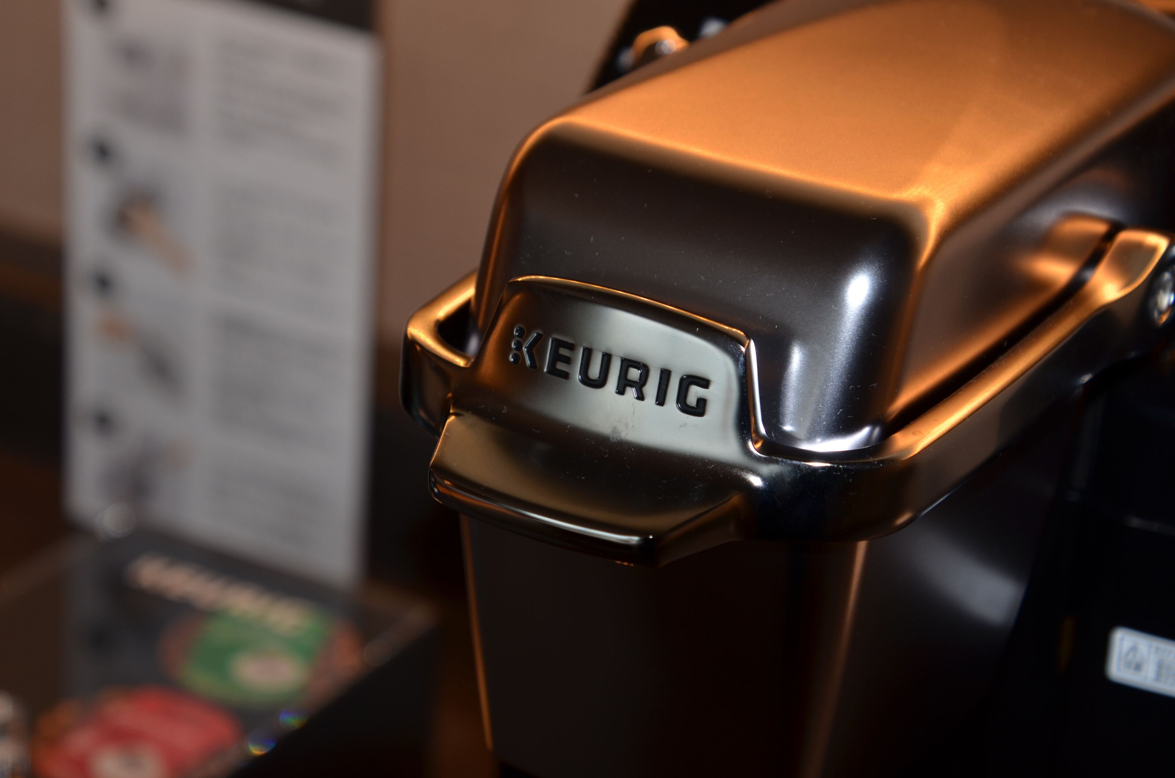 A close-up of a KEURIC coffee machine with a metallic finish.