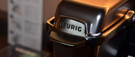 A close-up of a KEURIC coffee machine with a metallic finish.