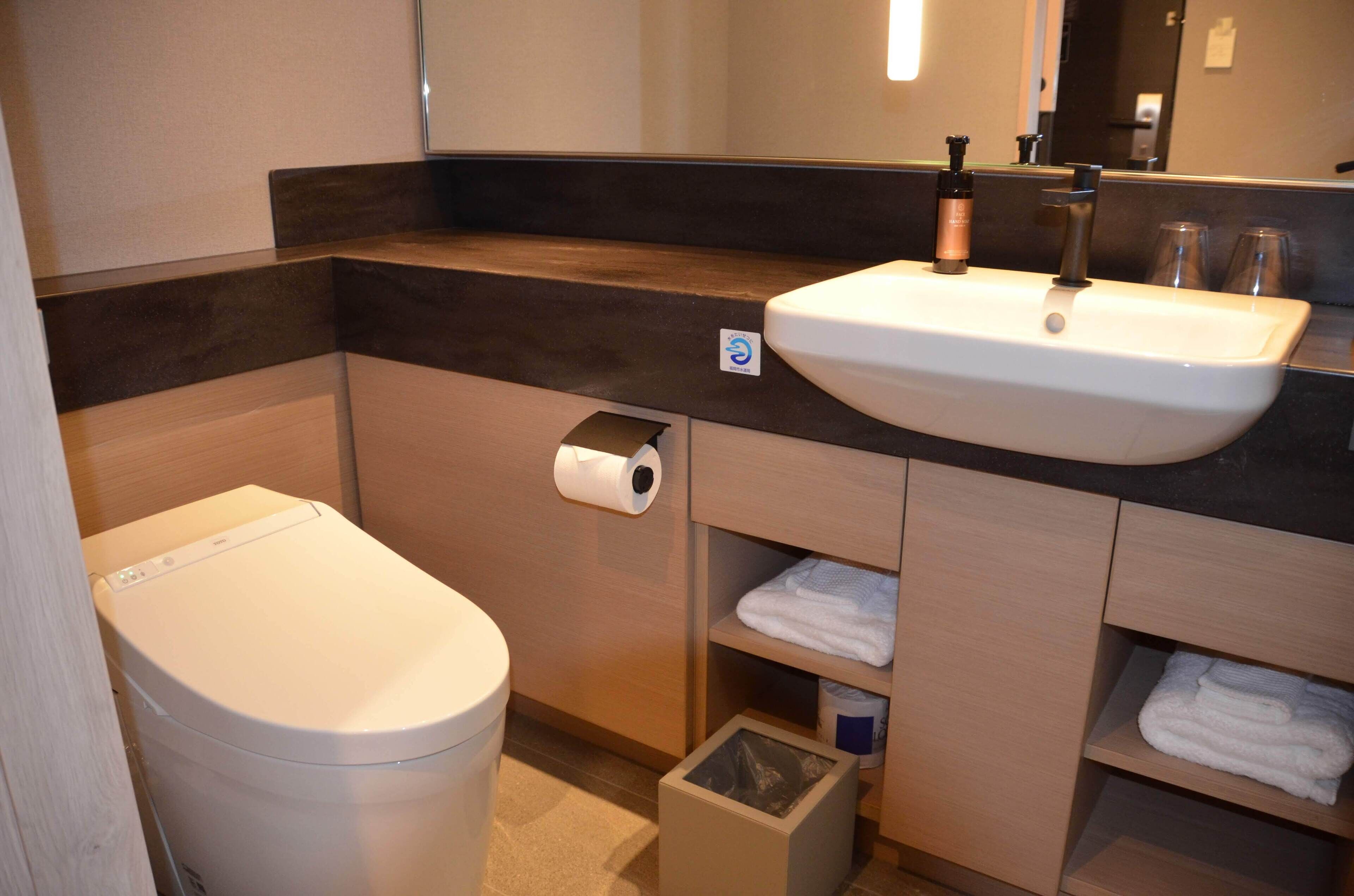 Ein modernes Badezimmer mit Waschbecken, Toilette und Spiegel.