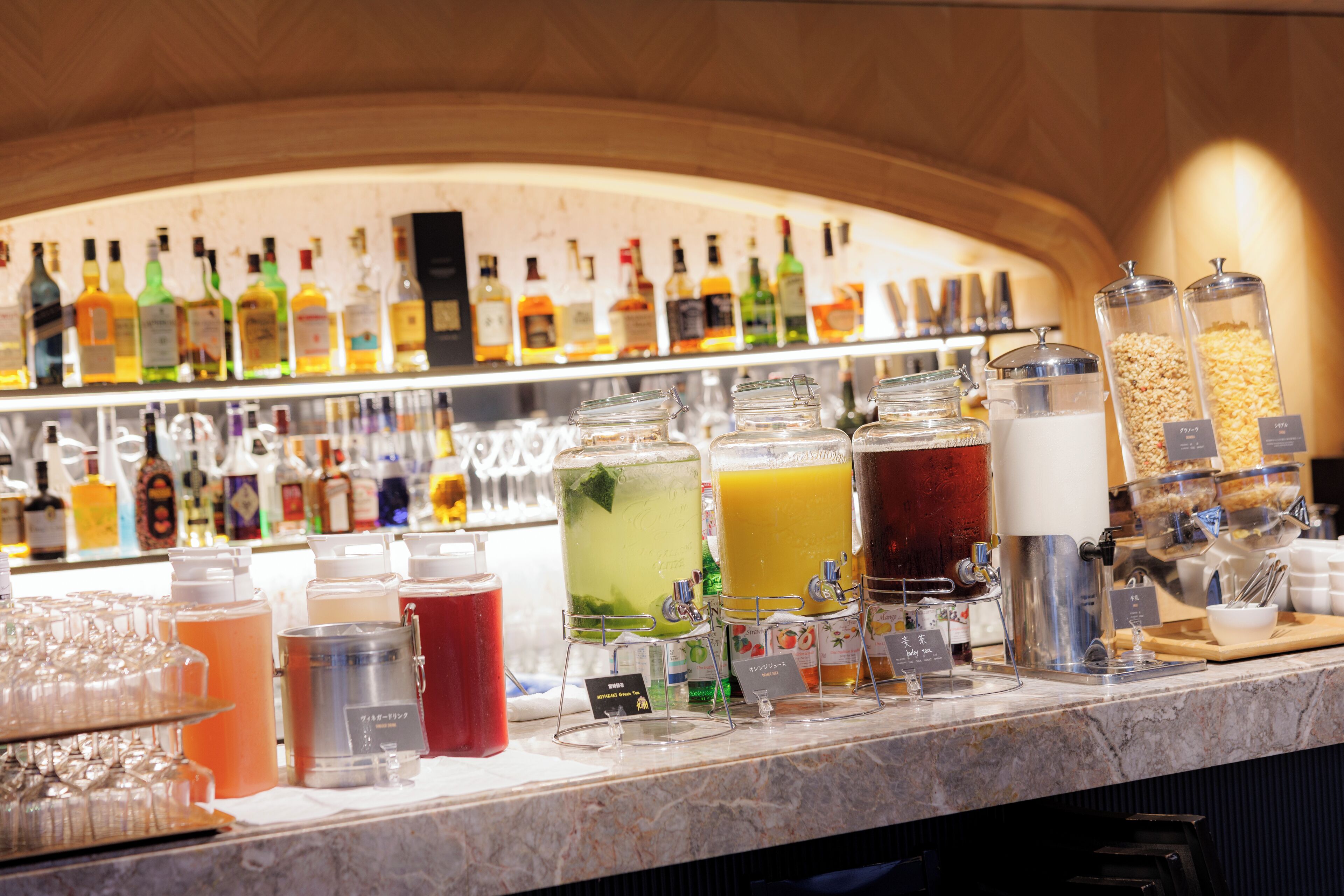Zona de bar con diversas bebidas y una selección de botellas al fondo.