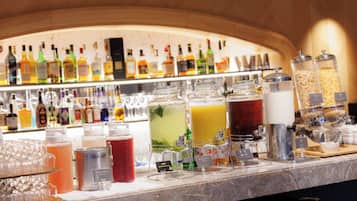 Zona de bar con diversas bebidas y una selección de botellas al fondo.
