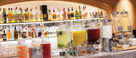 A bar area with various beverages and a selection of bottles in the background.
