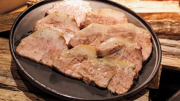 En tallrik med uppskivat kött på ett träbord.