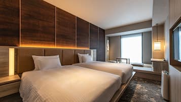Una habitación de hotel con dos camas, un ventanal grande y un diseño moderno.