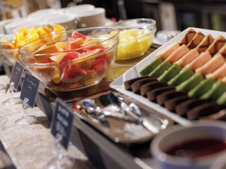 A buffet with various fruits and pastries.
