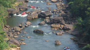 Un fiume con diverse imbarcazioni che solcano un percorso roccioso.