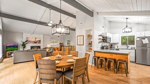 Une cuisine spacieuse dotée d’un grand îlot central, de planchers en bois et d’appareils électroménagers modernes.
