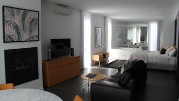 Una moderna camera d'albergo con zona soggiorno, camera da letto, bagno e sala da pranzo.