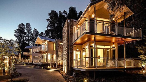 A modern multi-story house with a balcony and large windows, surrounded by trees. - Hepburn Bathhouse & Spa Villas (Hepburn Springs)