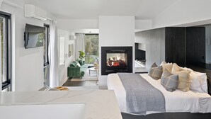 A modern bedroom with a large bed, a fireplace, and a view of the outdoors. - Hepburn Bathhouse & Spa Villas (Hepburn Springs)