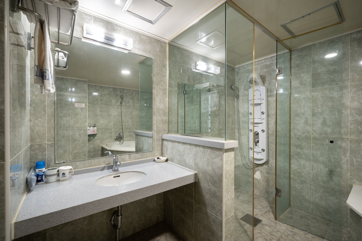 combined shower/bathtub, deep-soaking bathtub, hair dryer, slippers